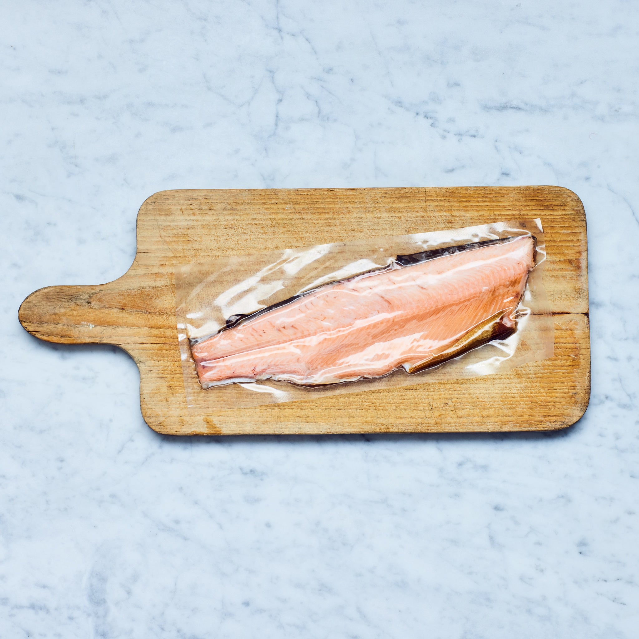 Frisch Gefischt geräuchertes Lachsforellefilet auf einem Holzschneidebrett.