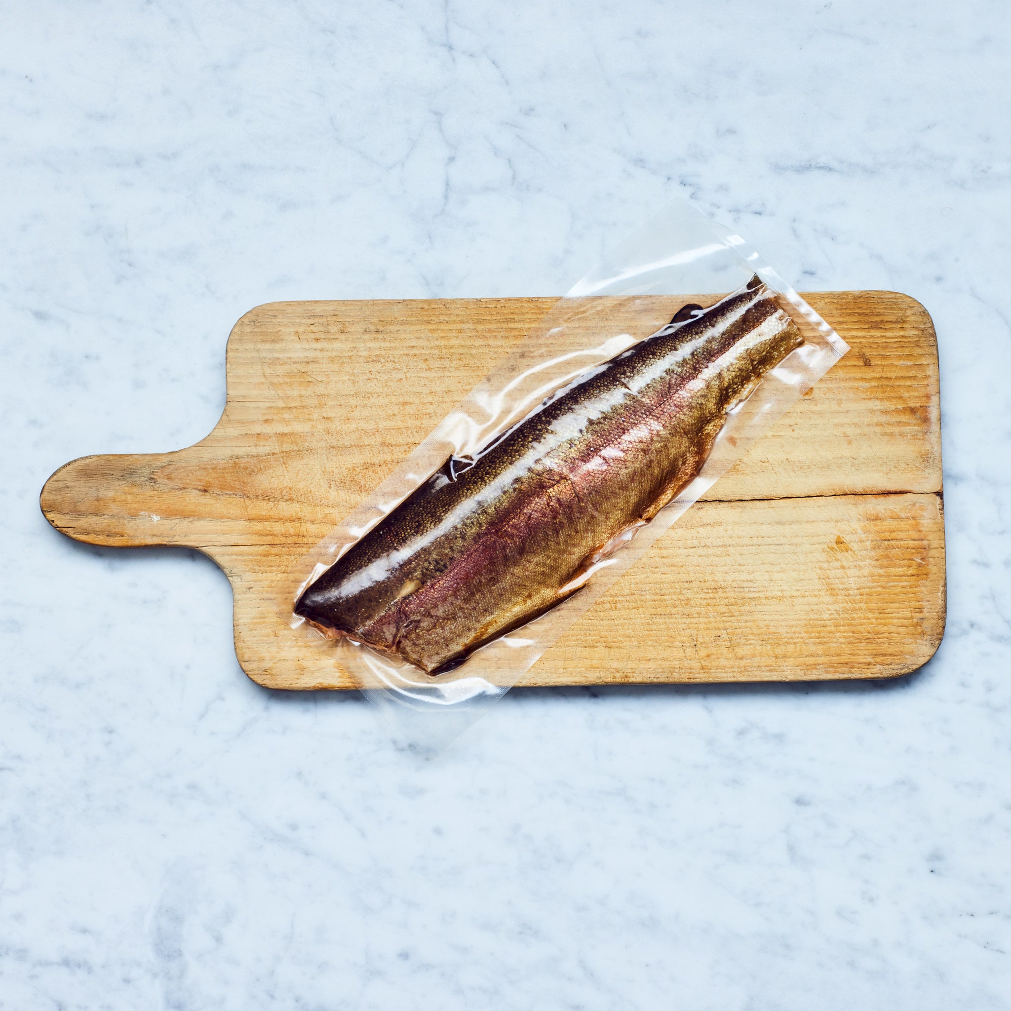 Nachhaltig geräuchertes Lachsforellenfilet mit Haut von Frisch Gefischt auf einem Schneidebrett.