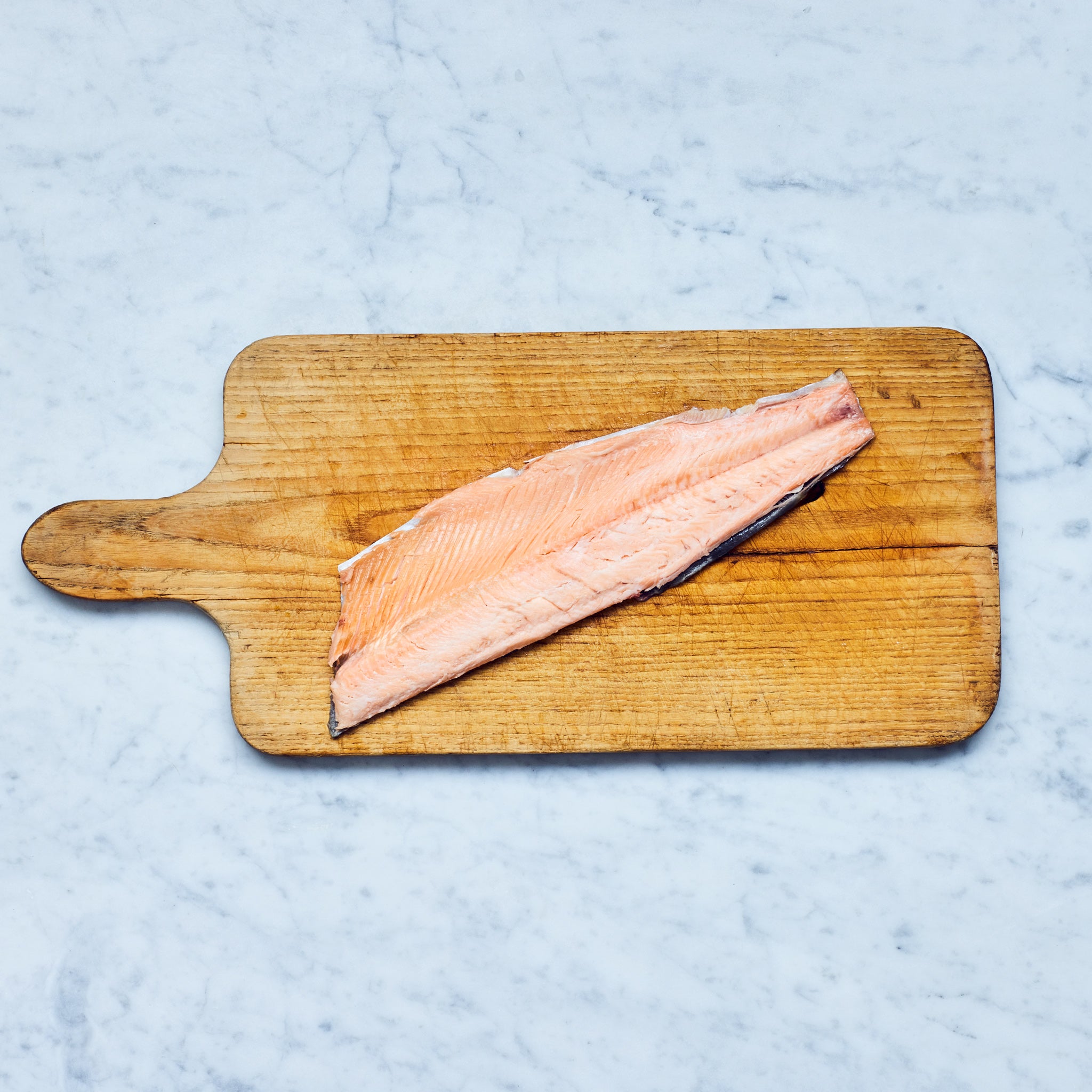 Nachhaltig geräuchertes Lachsforellenfilet mit Haut von Frisch Gefischt auf einem Schneidebrett.